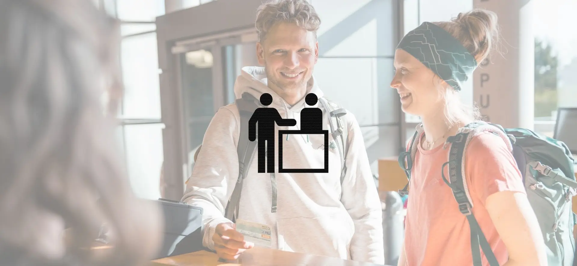 Ein Mann und eine Frau informieren sich an einem Tresen in der Kletterhalle über das Angebot | © DAV / Marisa Koch